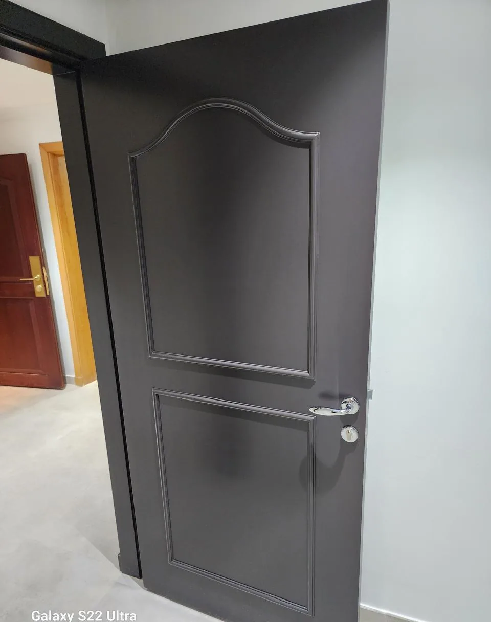 Panelled interior door painted charcoal grey with a matching frame