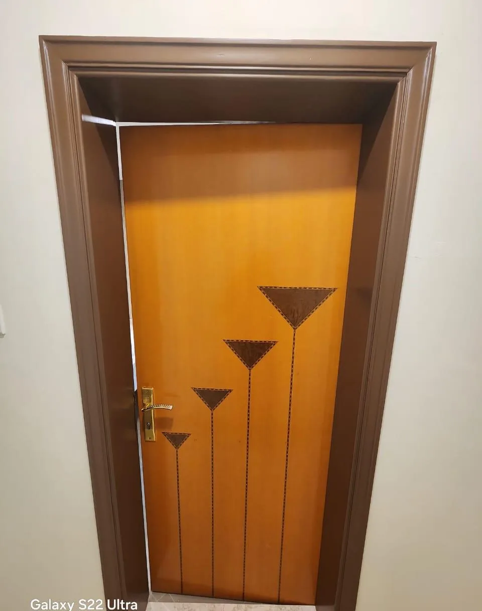 Wooden door with an inlay design set in a dark brown painted frame